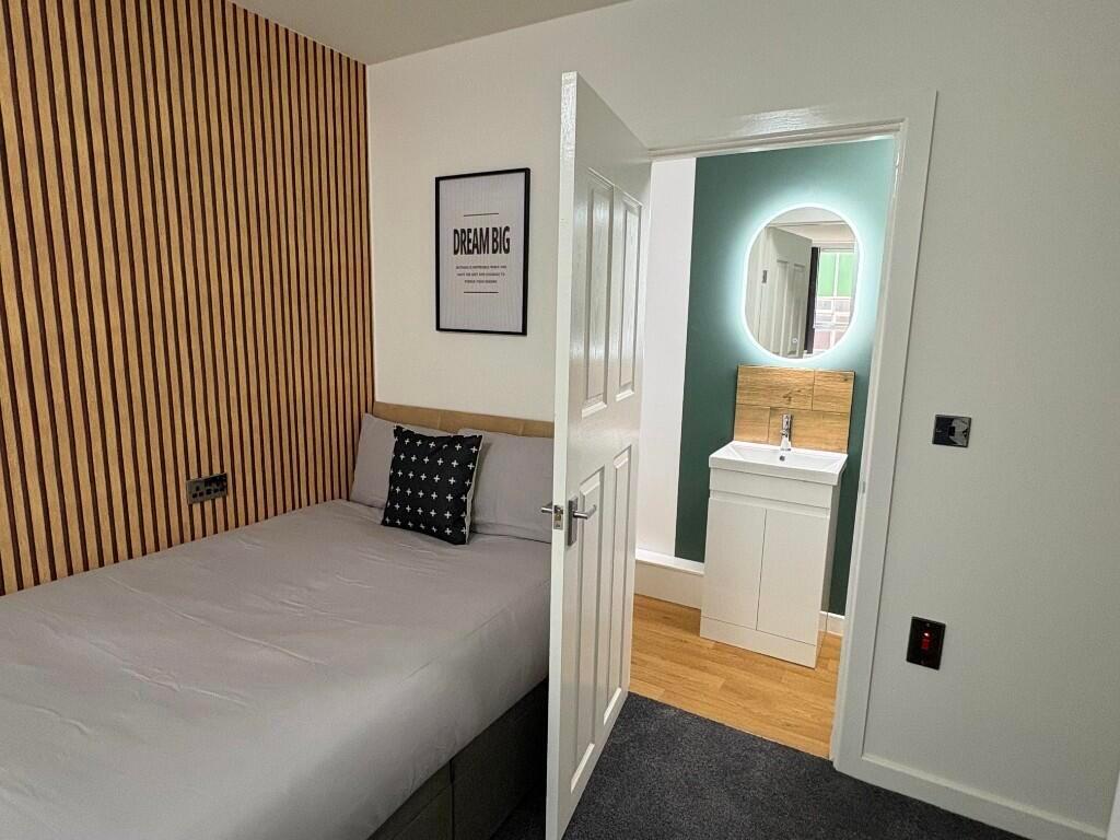 A modern double bedroom featuring a neatly made...