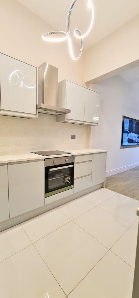 Modern, bright kitchen with sleek white cabinet...