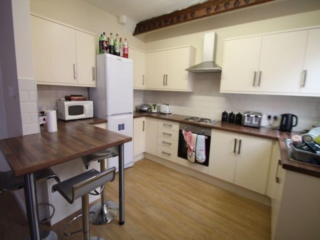 Bright and modern kitchen with white cabinetry,...