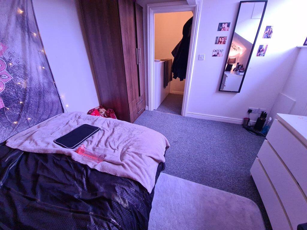 A cozy single bedroom featuring a bed with soft...