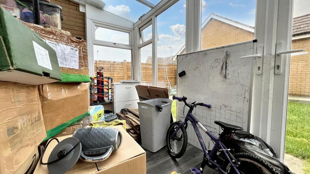 A cluttered but spacious conservatory with pote...