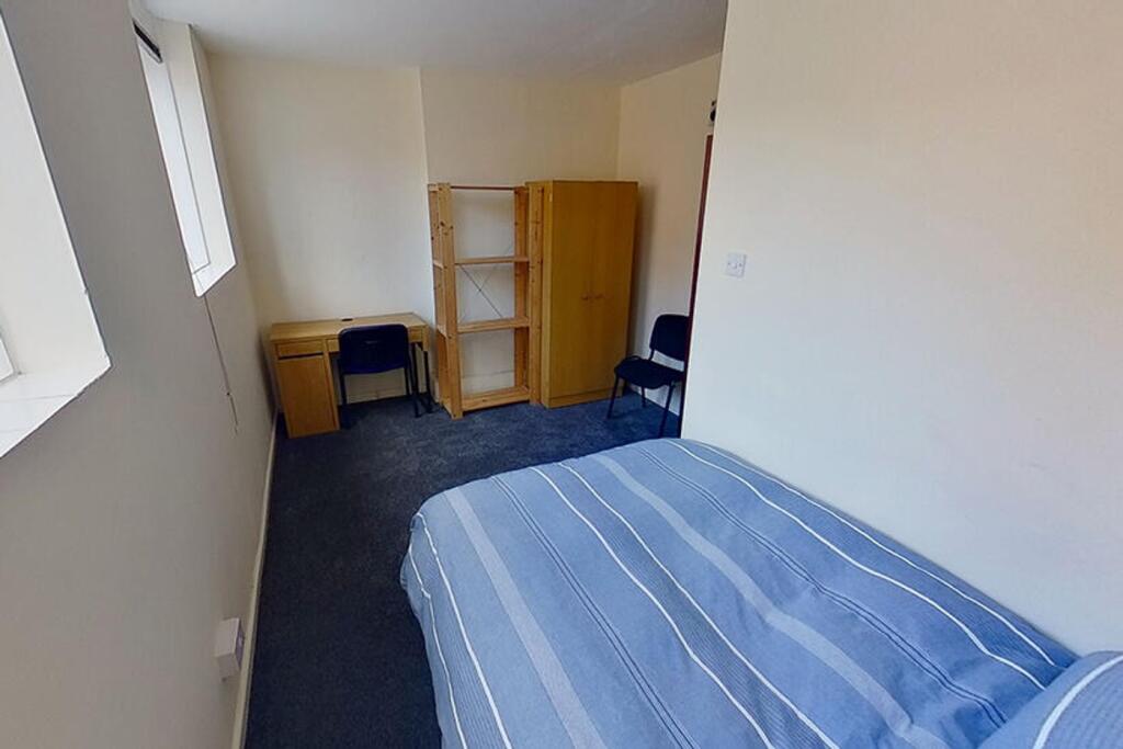 This inviting double bedroom features a cozy at...