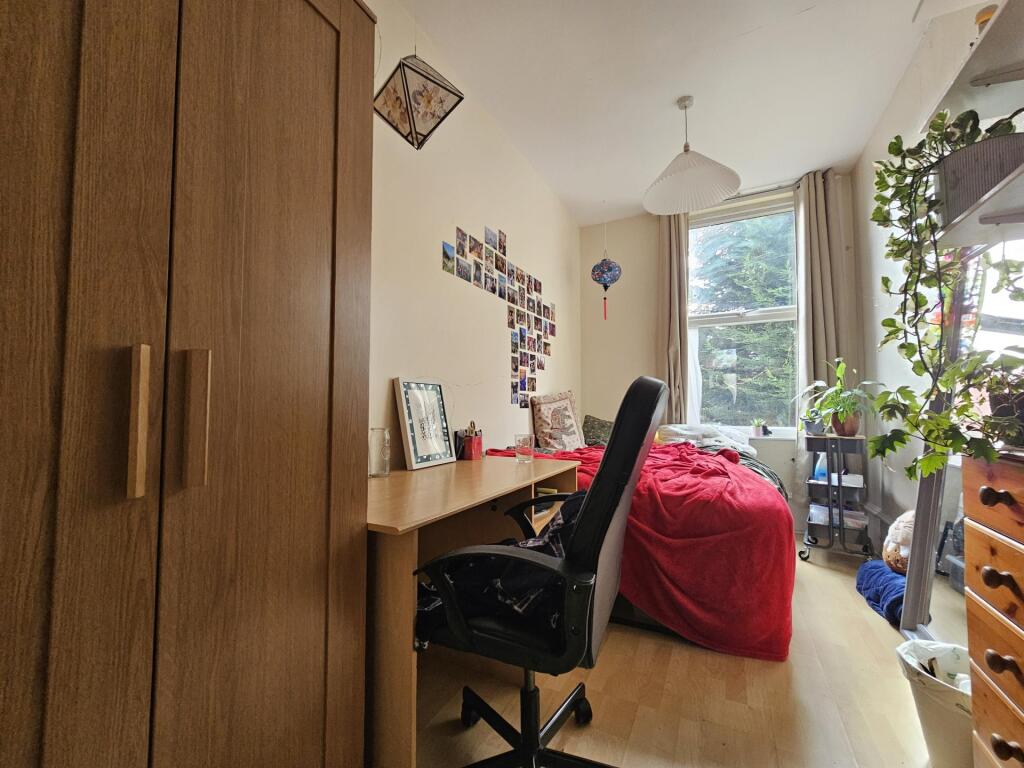 Bright, neatly arranged bedroom with a large wi...