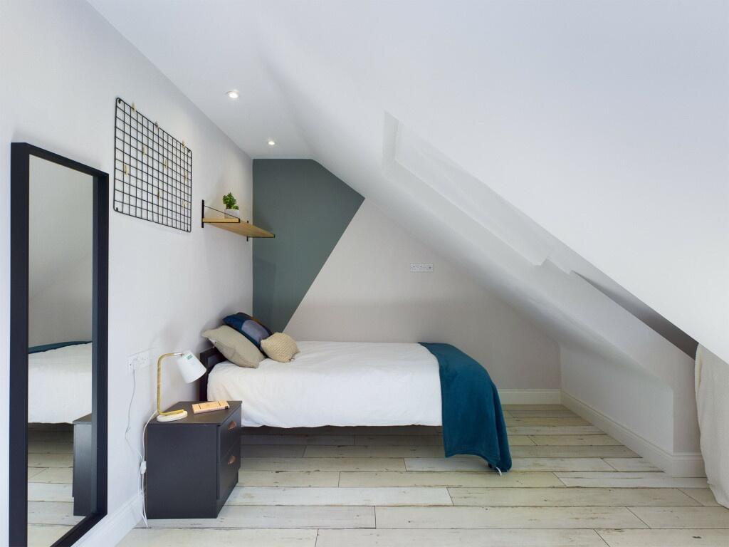 A bright and stylish double bedroom featuring a...