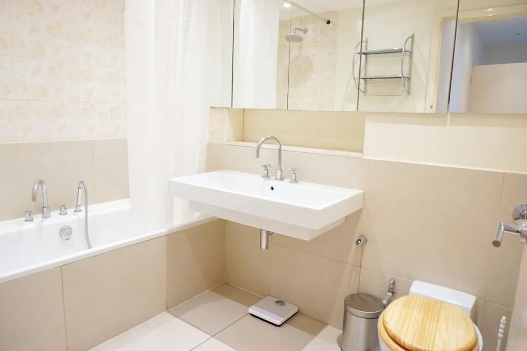 Bright and clean bathroom suite featuring a mod...