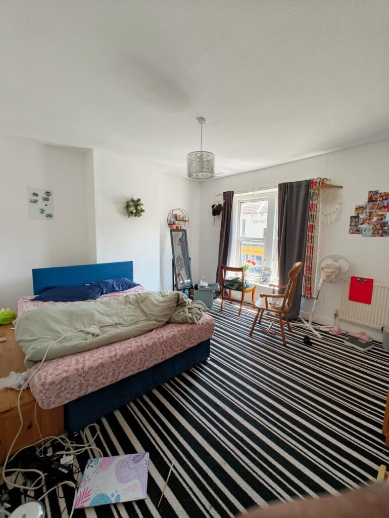 Bright double bedroom with a large window allow...