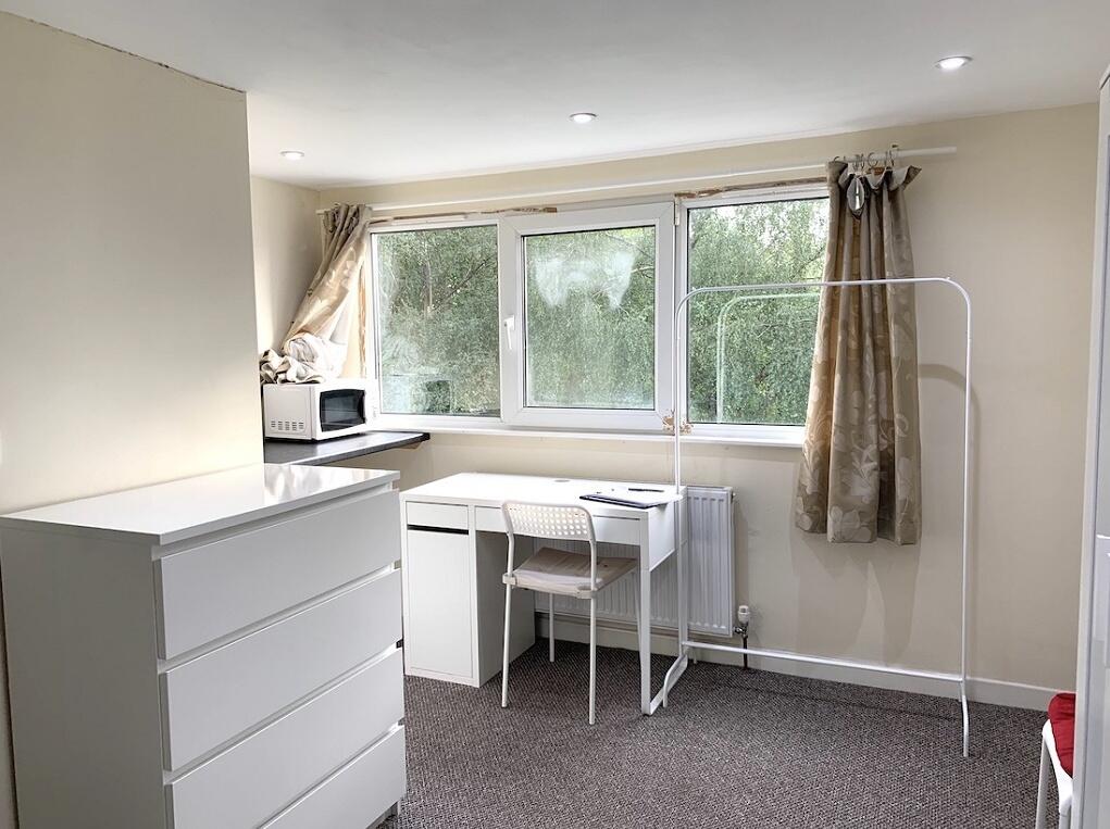 A bright and tidy single bedroom featuring a wh...