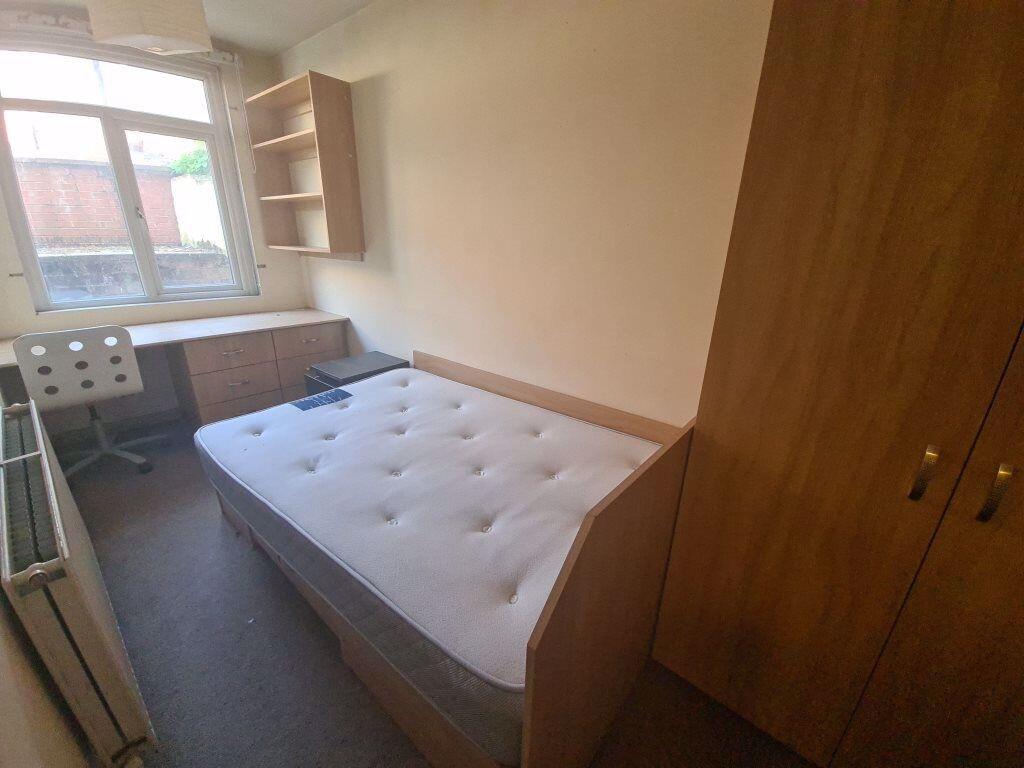 A bright single bedroom featuring a comfortable...