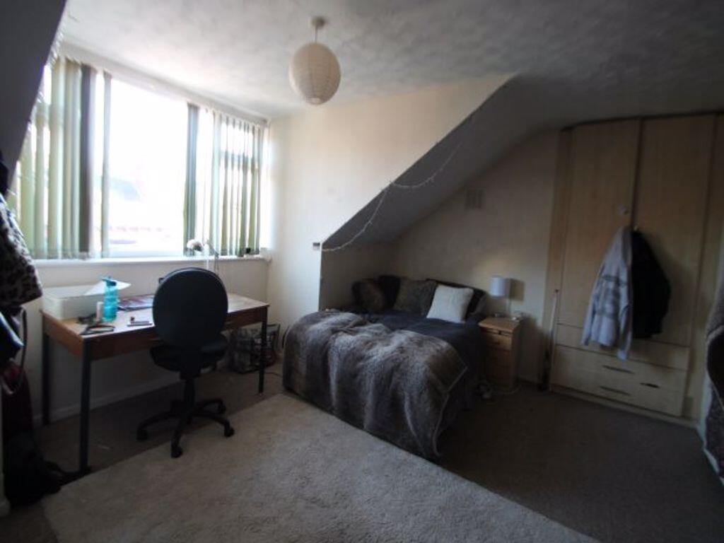 A cozy single bedroom featuring a comfortable b...