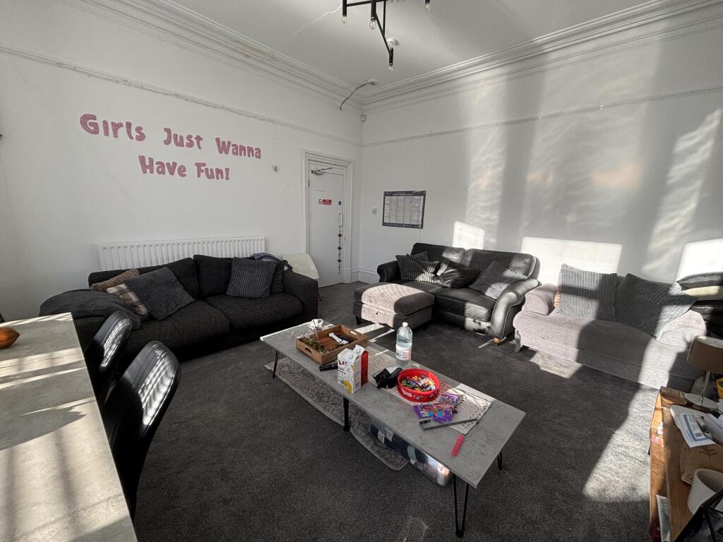 Bright communal lounge with multiple comfortabl...