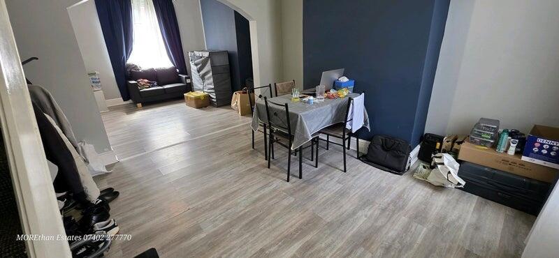 A spacious living room with light wooden floori...