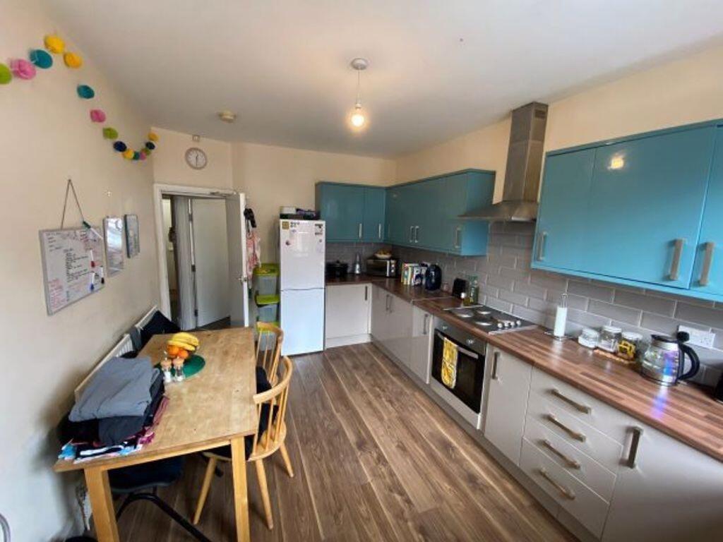 A modern kitchen with sleek blue cabinets and w...