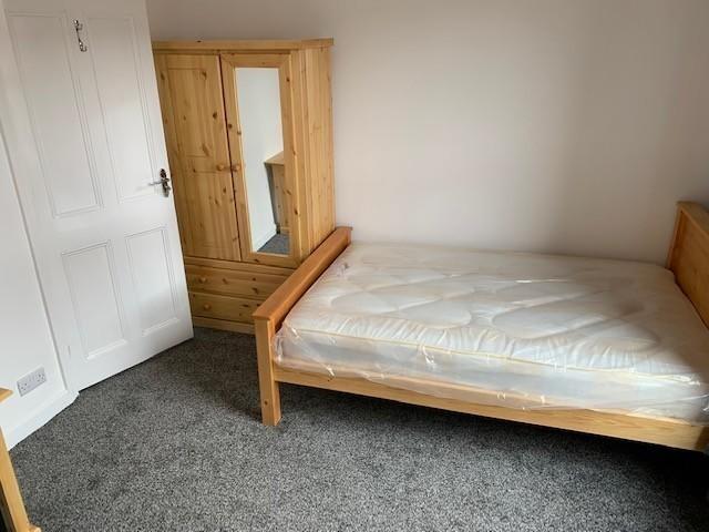 A simple, tidy single bedroom featuring a woode...