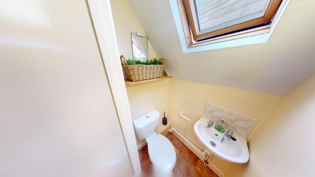 A clean and tidy single toilet with natural lig...