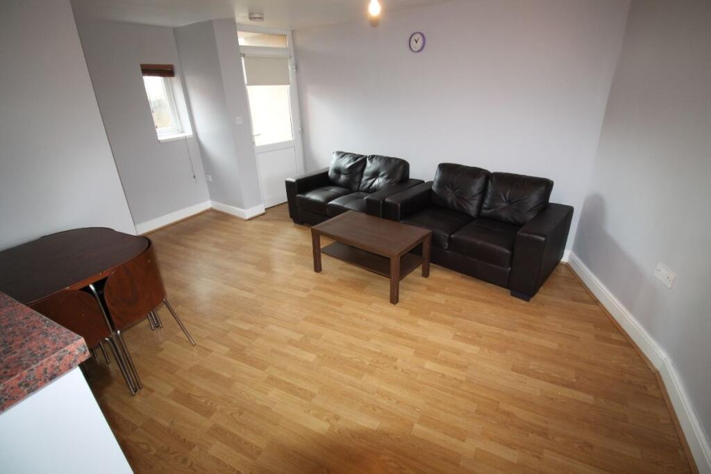 A contemporary living room featuring wood floor...