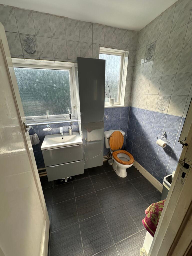 A bright bathroom featuring modern grey and blu...