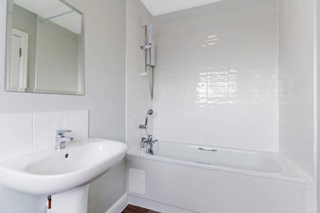 A clean and modern bathroom featuring a bath an...