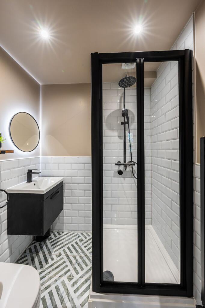 Modern bathroom with a glass-enclosed shower, s...