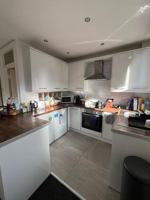 Modern fitted kitchen with white cabinets, inte...