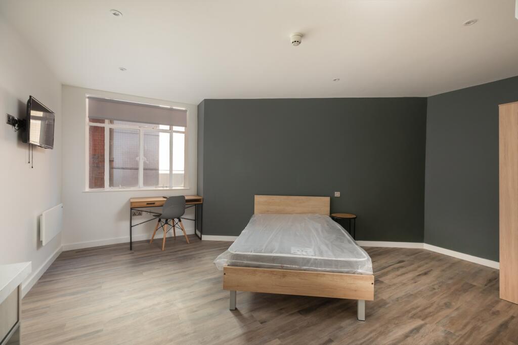A spacious and well-lit double bedroom, perfect...