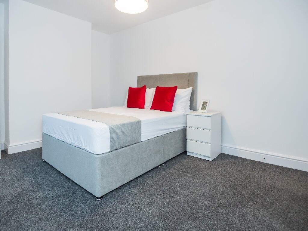 A modern and tidy double bedroom featuring a co...