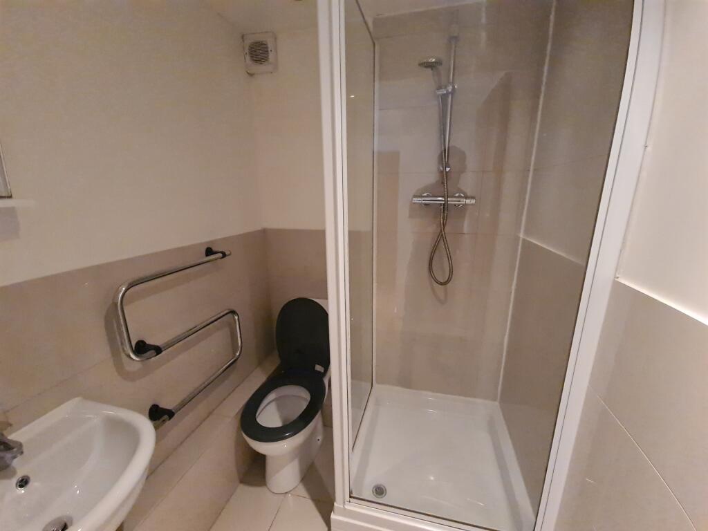 A clean, modern bathroom featuring a shower enc...