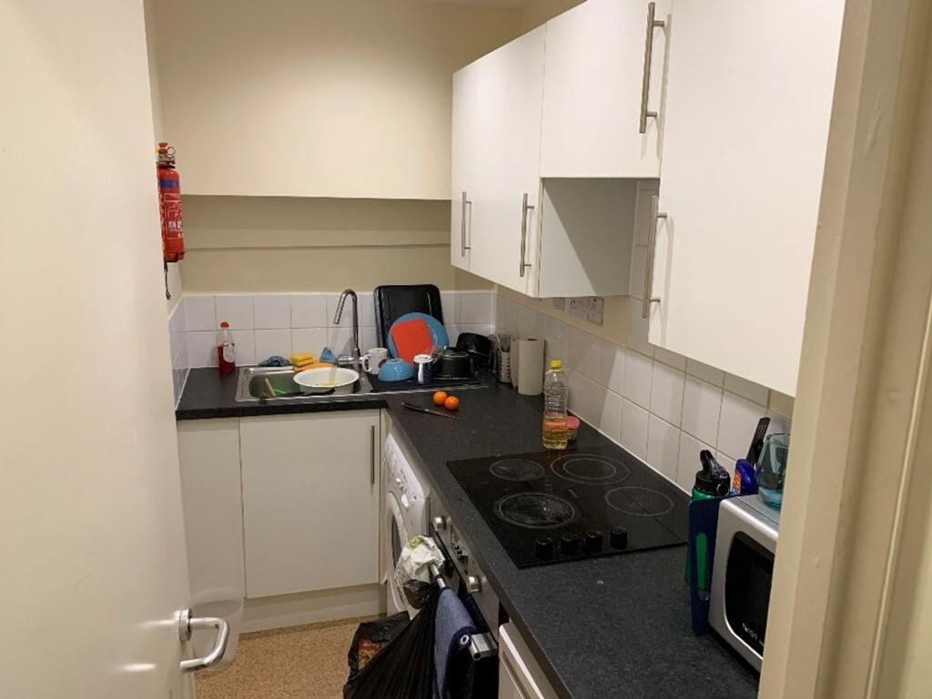 A compact kitchen equipped with essential appli...