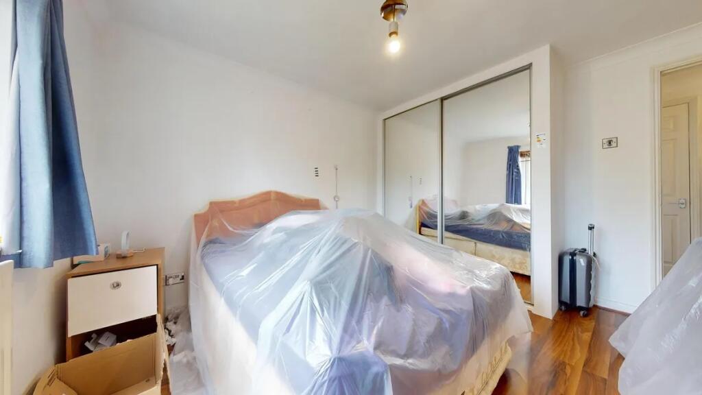 A well-lit double bedroom featuring a large bed...