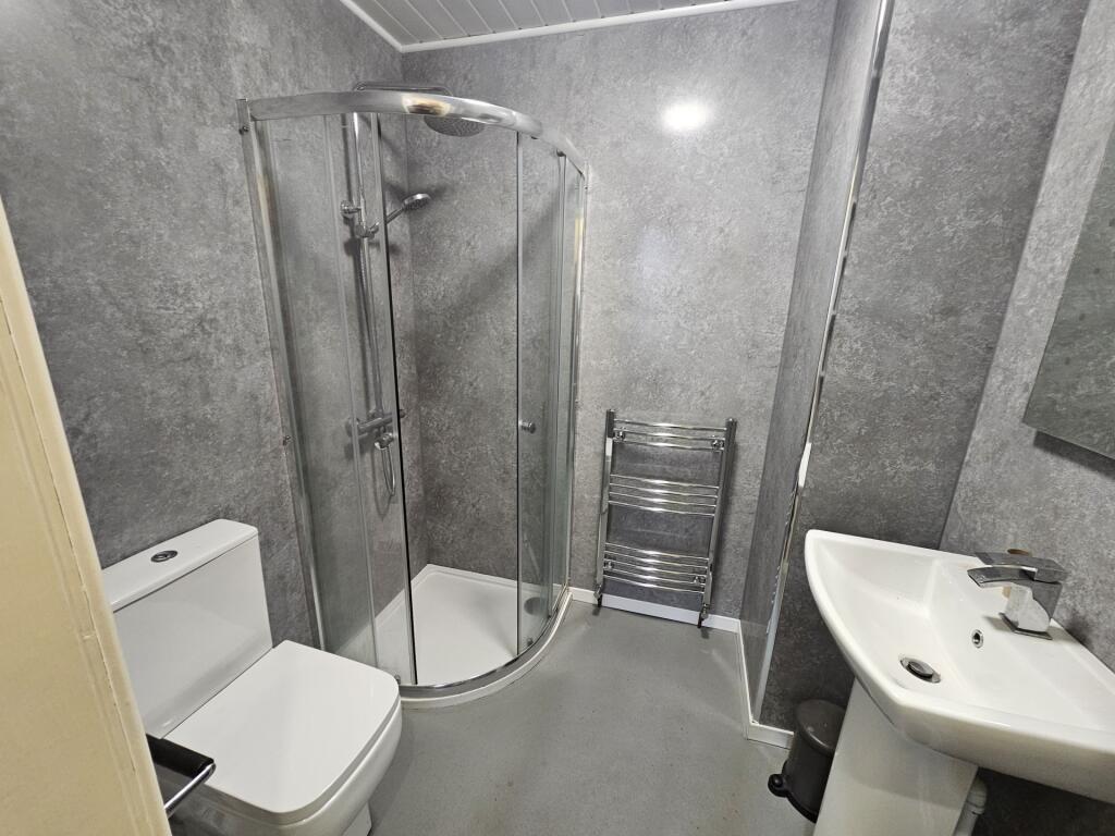 Modern bathroom featuring a spacious curved gla...