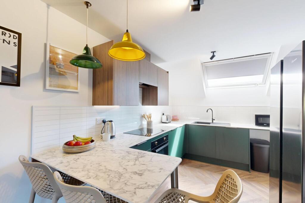 Modern fitted kitchen with marble-effect breakf...