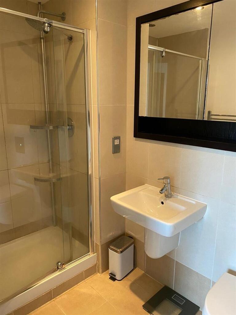 A modern bathroom featuring a clear glass showe...