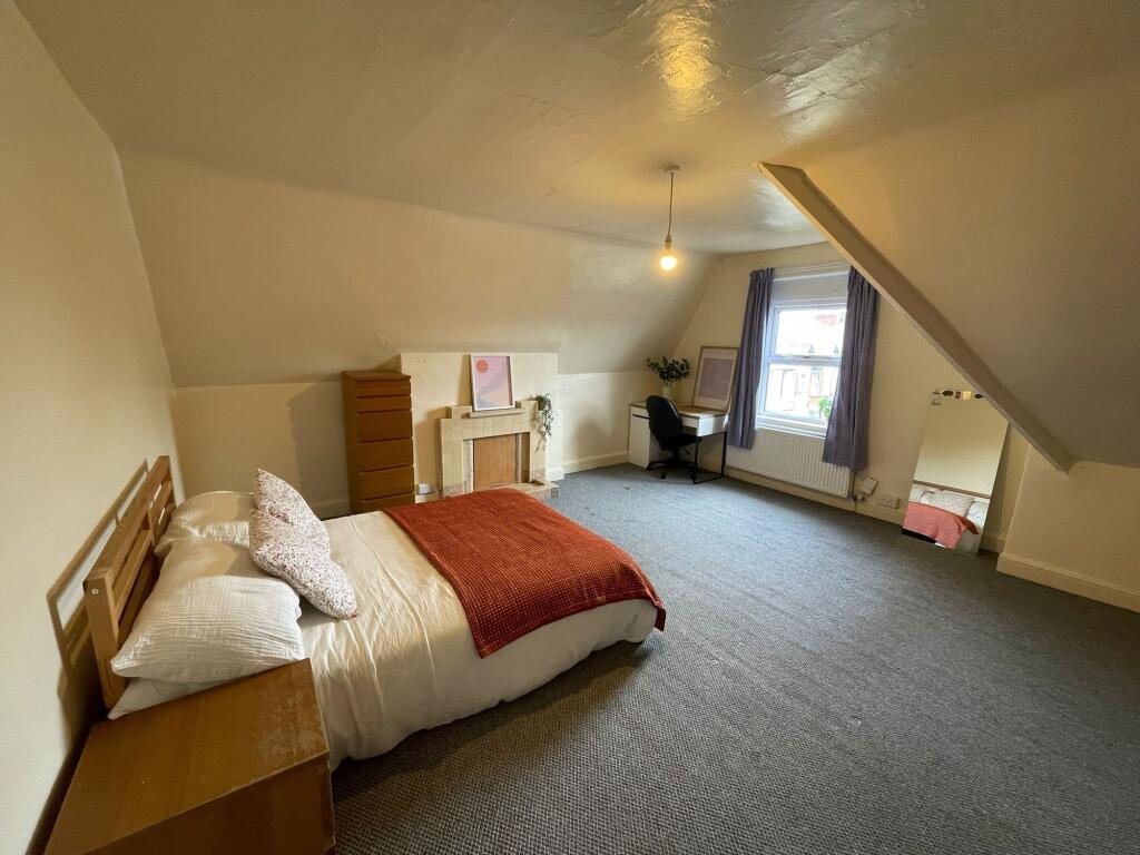 A spacious and inviting bedroom featuring a com...