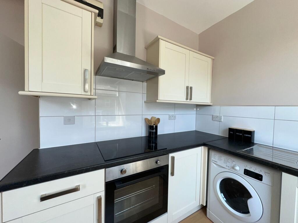 Bright and clean kitchen featuring modern white...
