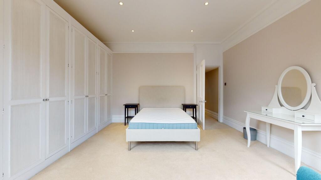 A spacious double bedroom featuring a neatly ma...