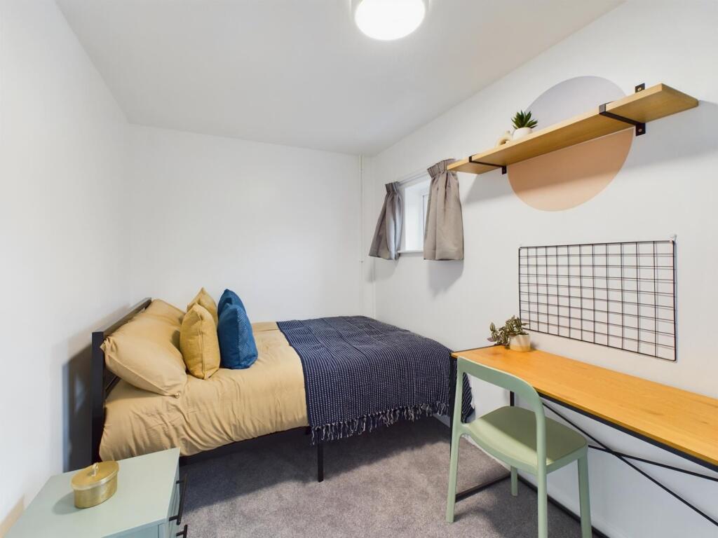 A cozy and well-lit double bedroom, featuring a...