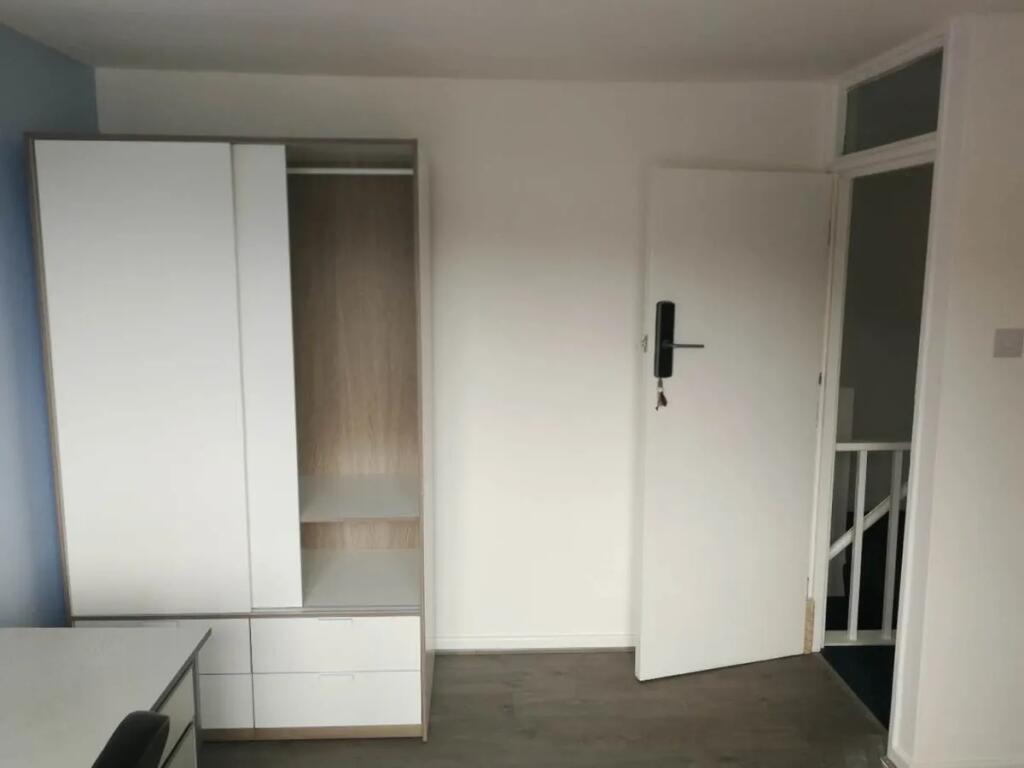 A clean and modern double bedroom featuring a w...