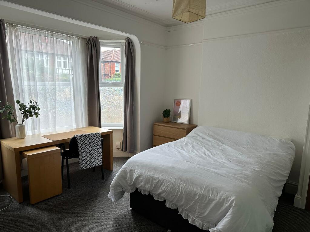 A bright and clean bedroom featuring a large wi...