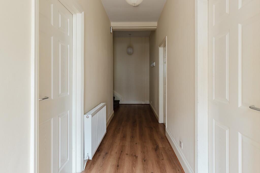 A well-maintained hallway featuring clean woode...