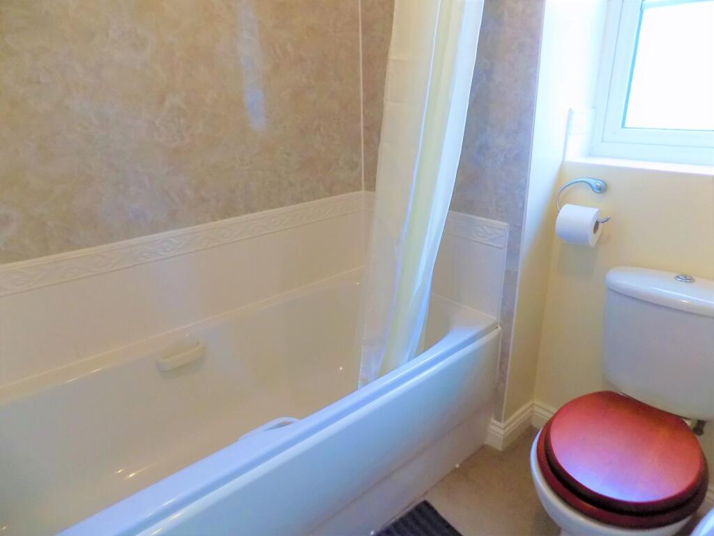 A bright and clean bathroom suite featuring a l...