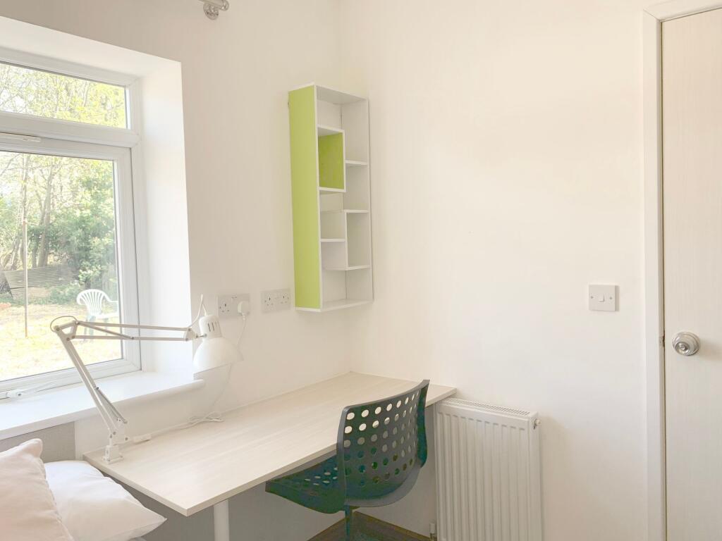 Bright and tidy single bedroom corner featuring...