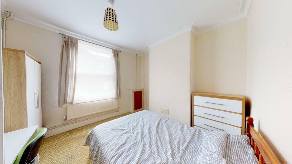 A bright double bedroom featuring a neatly made...