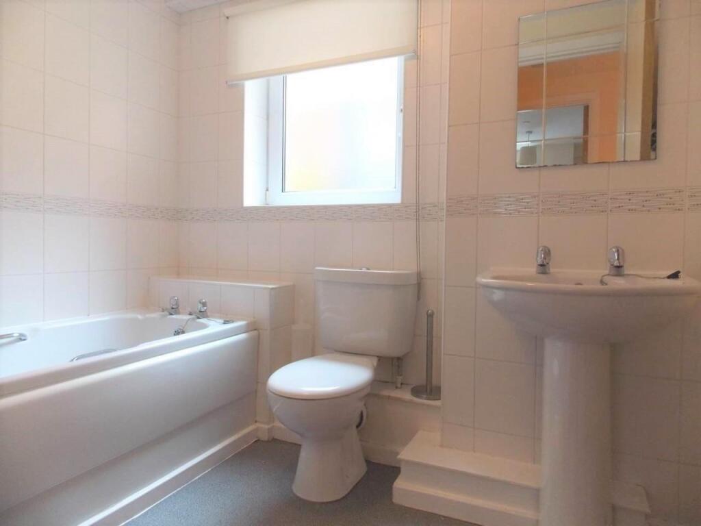 Bright and clean bathroom suite featuring a spa...