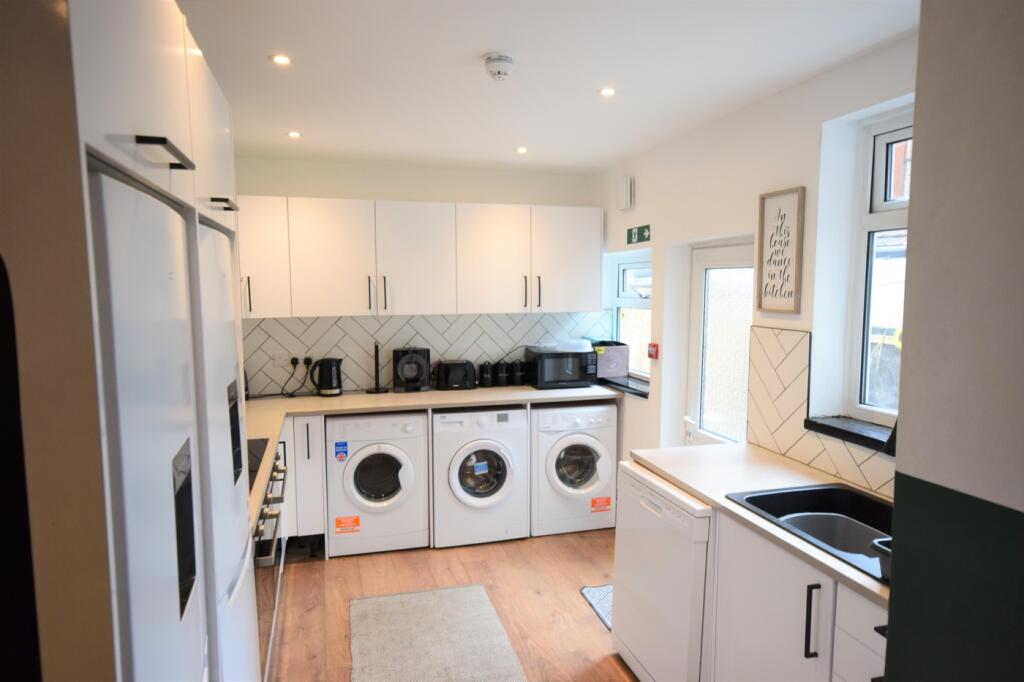 A spacious and bright kitchen equipped with mod...