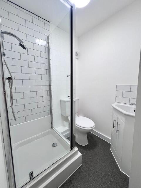 A modern bathroom featuring a clean shower cubi...