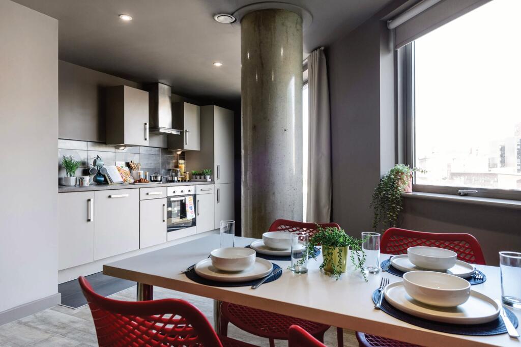 Modern kitchen area featuring sleek cabinetry a...