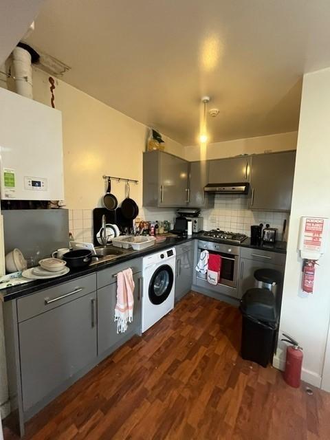 Modern compact kitchen with grey fitted cabinet...
