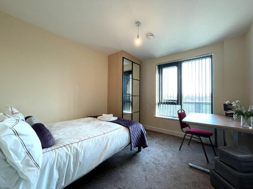 A neat and cozy single bedroom featuring a comf...