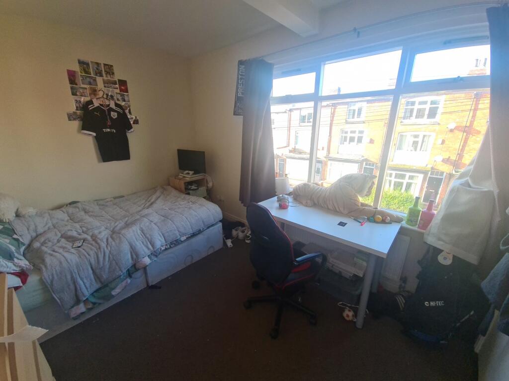 A cozy student bedroom featuring a single bed, ...