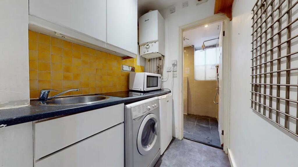 Compact kitchen space featuring modern white ca...
