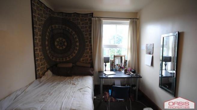 A well-lit bedroom featuring a comfortable bed ...